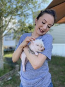 pretty woman holding a baby pig