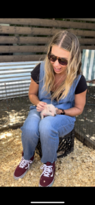 woman holding petting a piglet